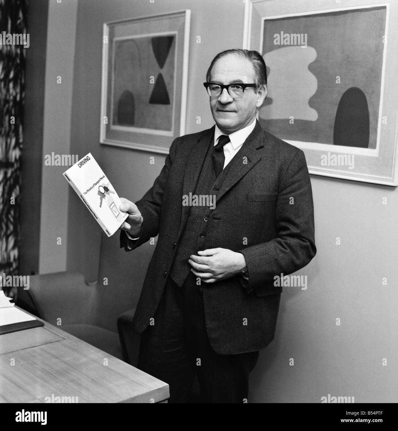 Politica. Fred Mulley Ministro dei trasporti delineato i suoi piani per un Natale di azionamento di sicurezza al Sunday Mirror motoring correspondent Roy Spicer questo pomeriggio. Tra la letteratura era un grande poster e un manuale di guida che il sig. Mulley suggerito (manuale) sarebbe un regalo di Natale ideale per ogni driver. Dicembre 1969 Z11580-004 Foto Stock