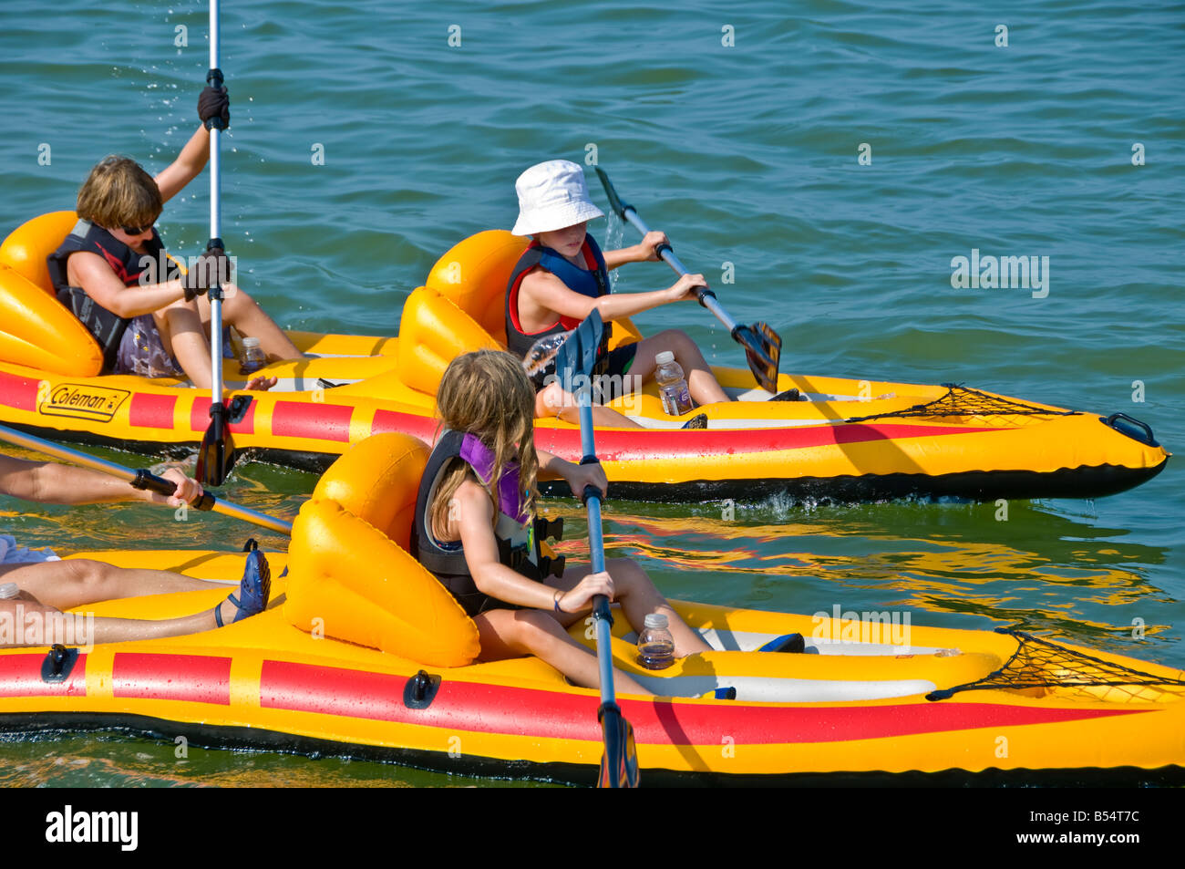 Ragazzi ragazza kayak racing gara colore brillante giallo gonfiabile in PVC sit-in-top kayak Foto Stock