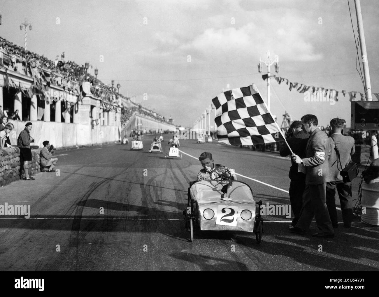 Soapbox vincitore rattles passato. Su ogni concepibile aggeggio che può essere pedalato i giovanotti erano fuori a Brighton ieri dando tutto quello che avevo avuto nel soapbox derby. Qui è J. Perkins, su 'Tartaruga Tolworth', contrassegnata come vincitore, Perkins e soffiato pedalato la sua strada per venire fino a dritto flat out per un emozionante vincere. Settembre 1950 ;P012098 Foto Stock