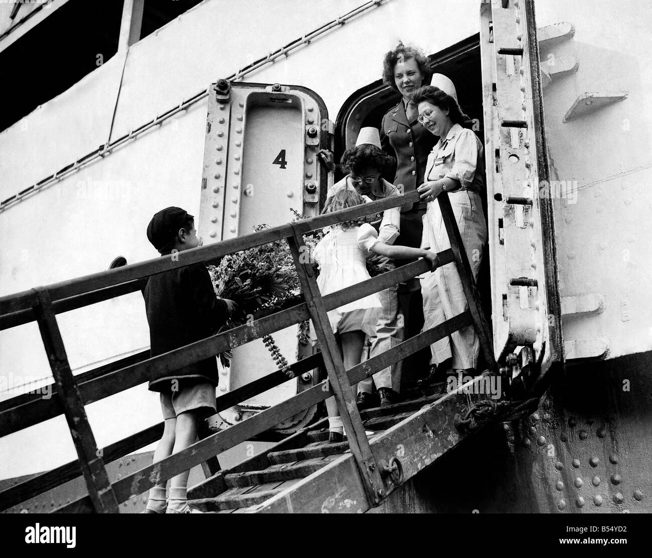 I bambini offrendo mazzi di fiori dai loro giardini per gli infermieri e i soldati feriti a bordo della nave ospedale attraccata a Foto Stock