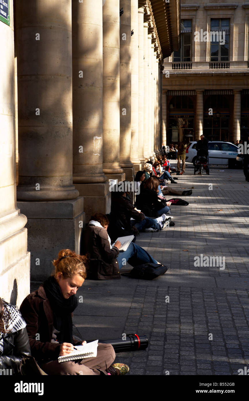 Arte francese agli studenti seduti sul pavimento esterno alla Comédie Française nel luogo Colette Parigi Francia Foto Stock