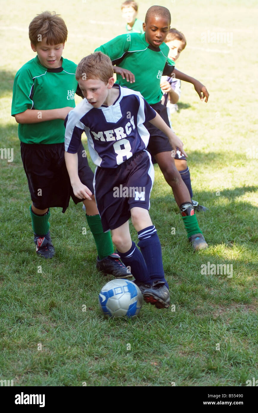 9 10 ragazzi di 11 anni giocare a calcio su un campo erboso in Maryland USA Foto Stock