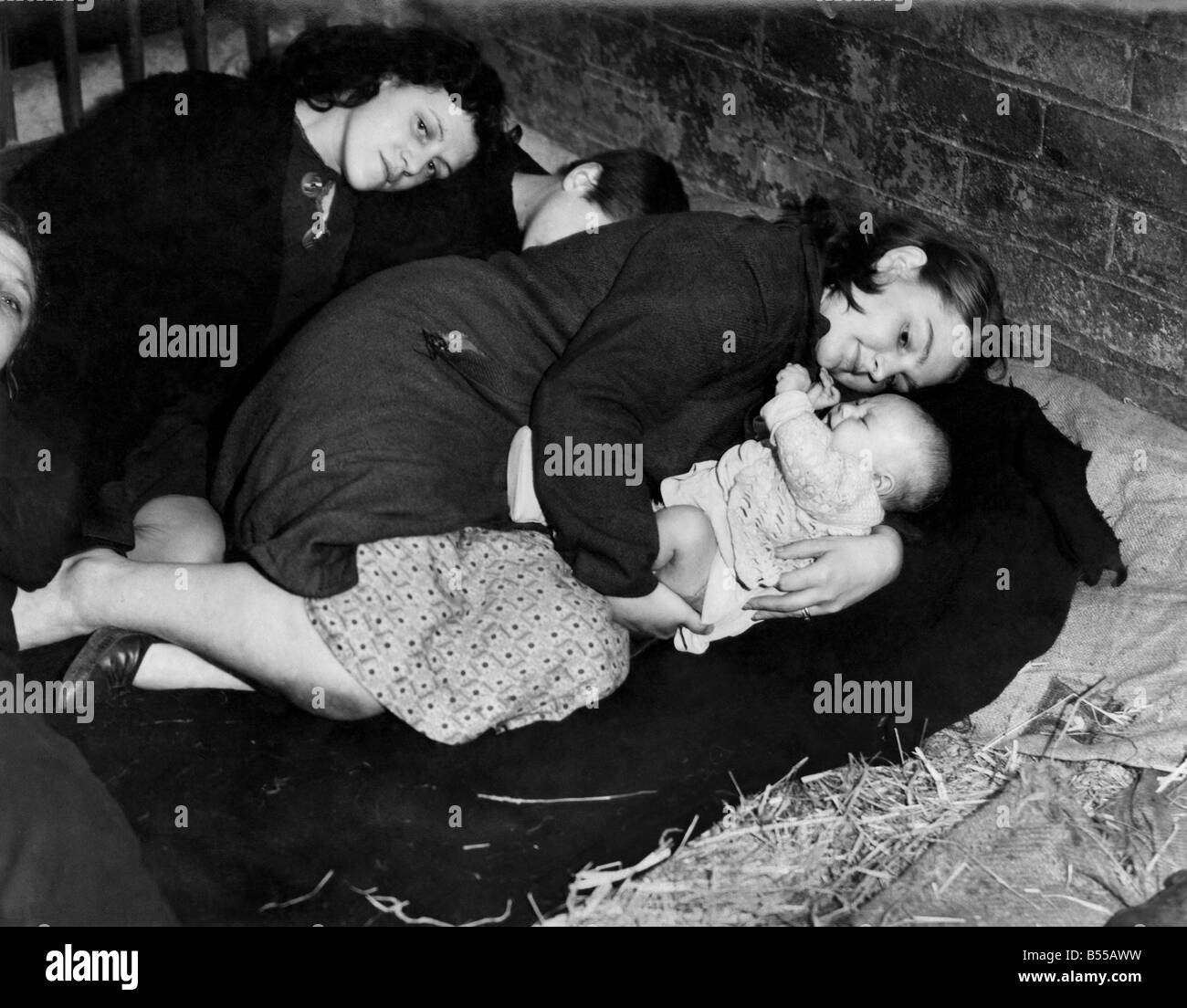 Una madre protegge il suo bambino pur tenendo il coperchio dalla Air Raid in un coltivatore fienile. Settembre 1941 P012295 Foto Stock