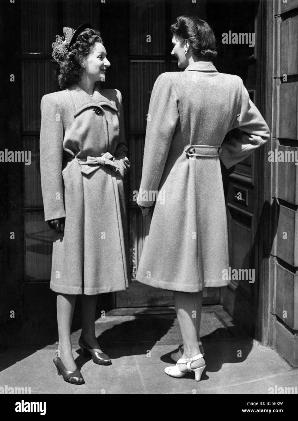 Moda 1946's: Ragazza a sinistra indossa un cappotto di cammello, è il capo dei puntatori di moda essendo il cucito Byron scollatura, vita-line tarature, e roll-gonna plissettata. I suoi grandi tasche contribuiscono a dare quella imbottita hip-effetto tanto di moda in questa stagione. Ragazza sulla destra indossa un cappotto di cammello con profonda con pinzatura a sella Dolman manicotti, il retro pieghettato essendo fissato da un due-abbottonatura mezza cintura. P008723 Foto Stock