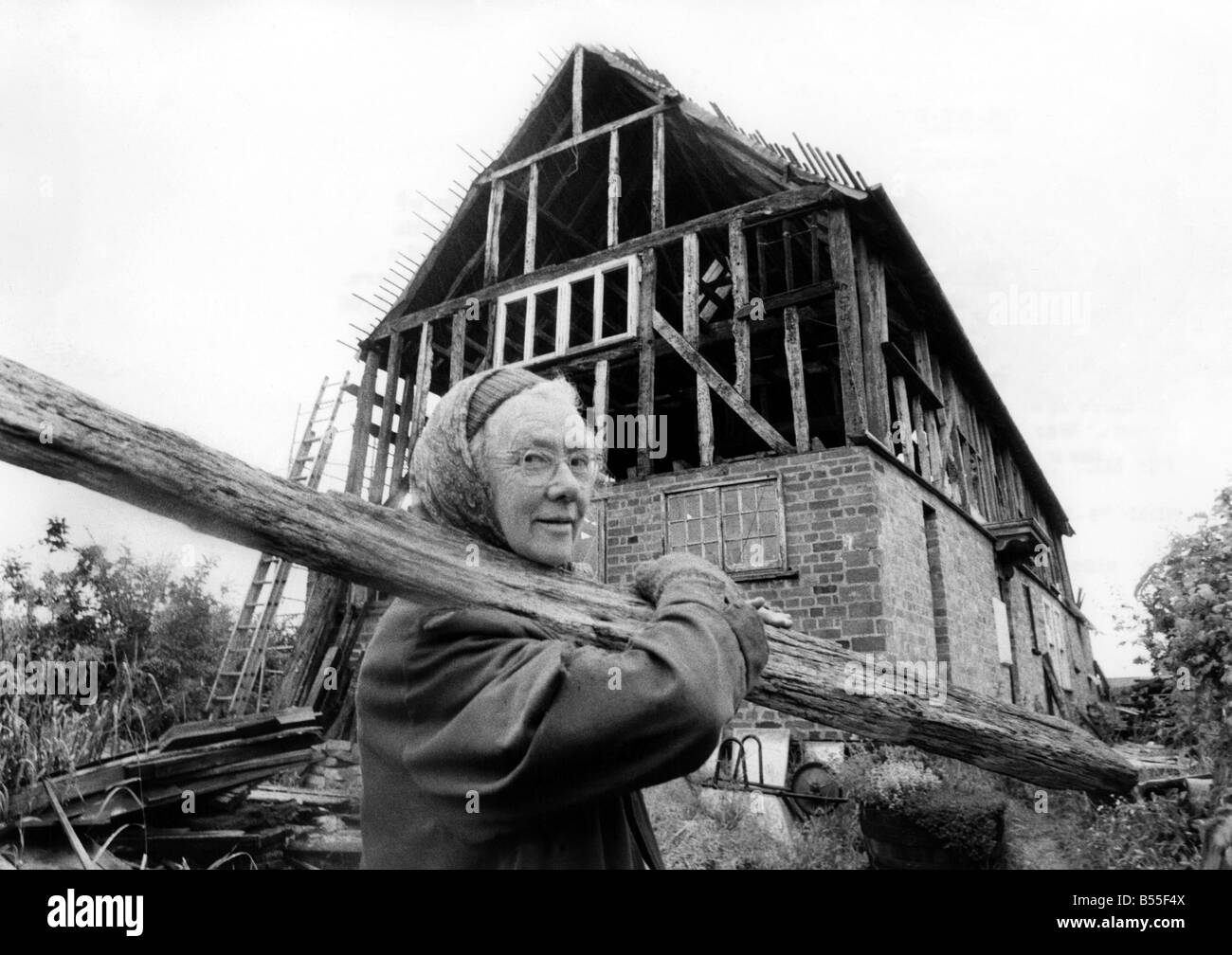 Donna anziana può al lavoro nella costruzione di casa sua. &#13;&#10;Luglio 1978 &#13;&#10;P009031 Foto Stock