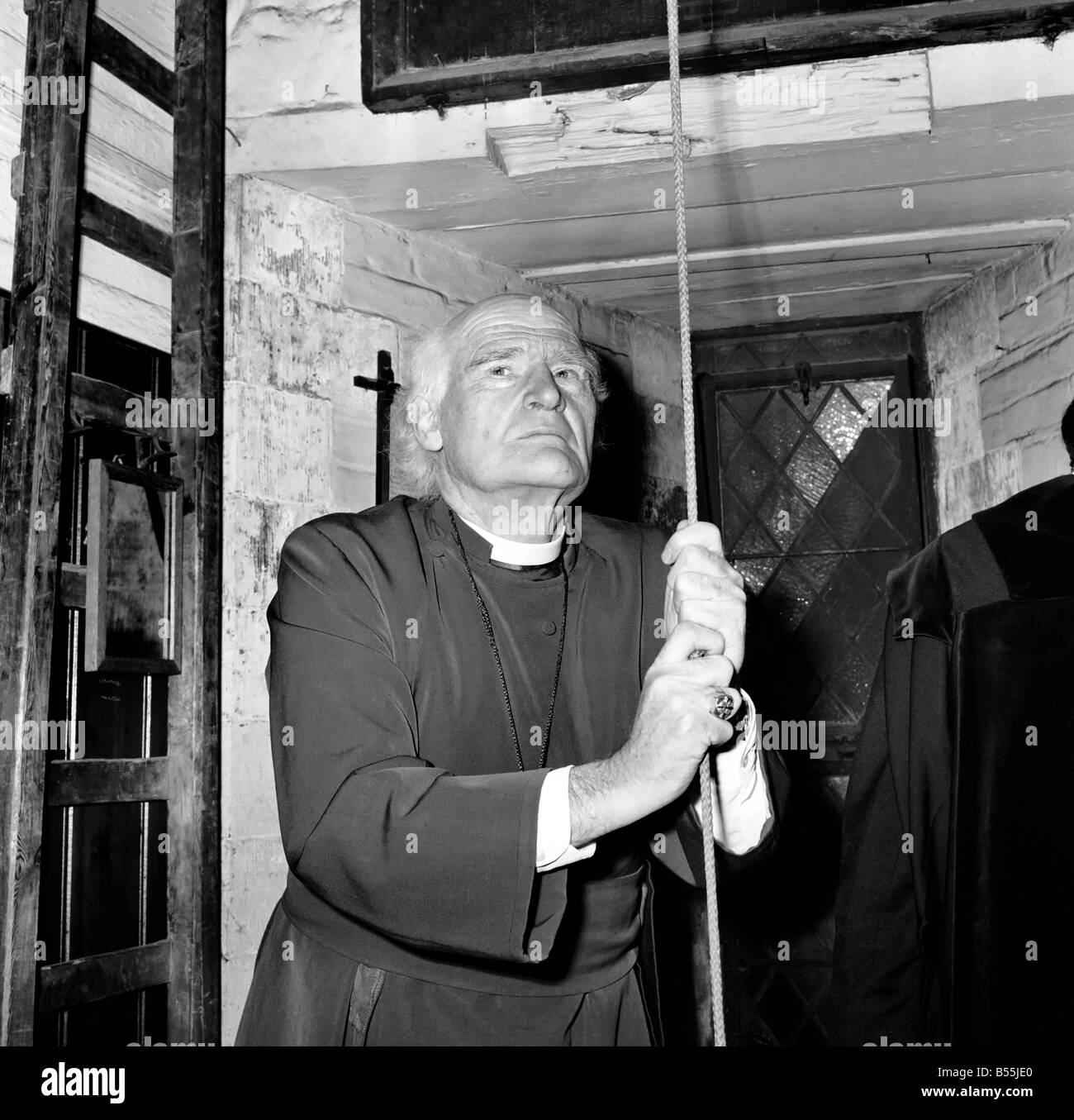 Religione: Arthur Michael Ramsey. L Arcivescovo di Canterbury suonando il campanello, in alto il campanile della cattedrale di Canterbury oggi (SAT). L Arcivescovo ha risalito la spirale di avvolgimento scalinata e ha suonato la campana 150 volte. Questo è stato il segnale per le campane della chiesa in tutta la Gran Bretagna per essere registrata per un'ora, in segno di protesta contro i milioni di persone che sono morte in Nigeria - Biafra guerra. Con l'Arcivescovo in alcune foto è Ralph Brasier, testa verger presso la Cattedrale di Canterbury. Dicembre 1969 Z12302 Foto Stock