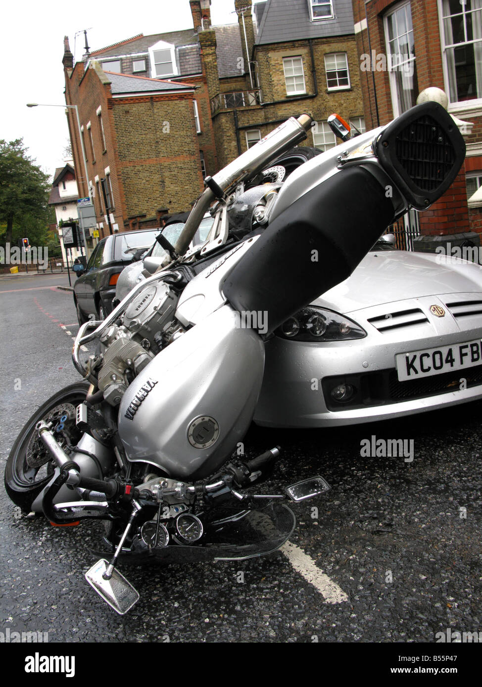 Un incidente motociclistico con moto di atterraggio su auto del cofano Foto Stock