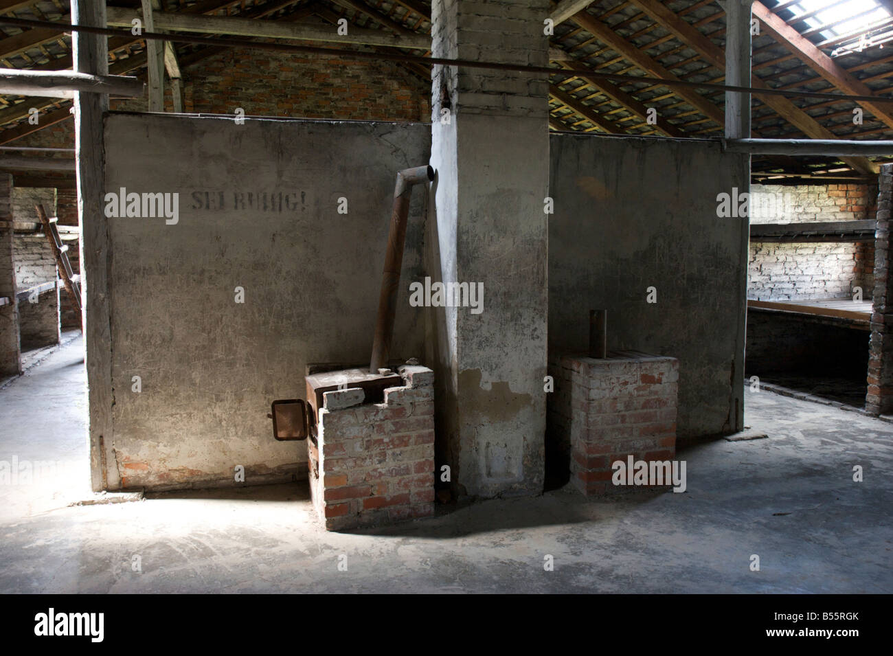 Mattone forni di riscaldamento all'interno di un prigionieri dormono barrack nell'ex campo di concentramento di Auschwitz II (Birkenau) Foto Stock