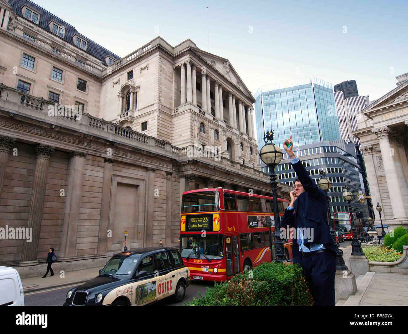 Uomo che parla al telefono e agitando vicino alla National Bank of England London REGNO UNITO Foto Stock