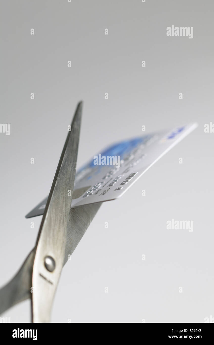 Il taglio di carta di credito con un paio di forbici Foto Stock
