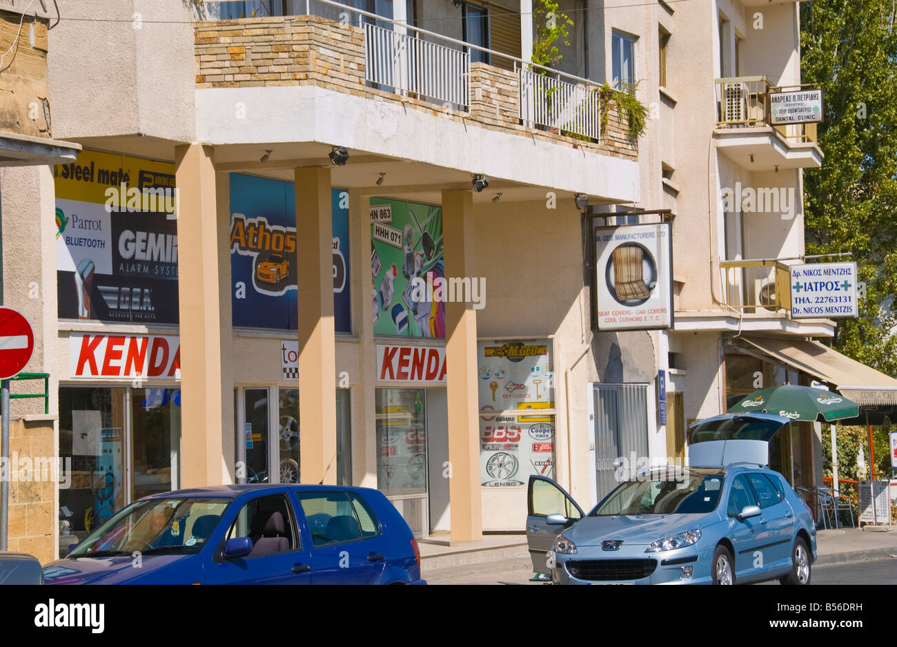 Via dello shopping nella città del sud Nicosia Cipro UE con le automobili parcheggiate fuori Foto Stock