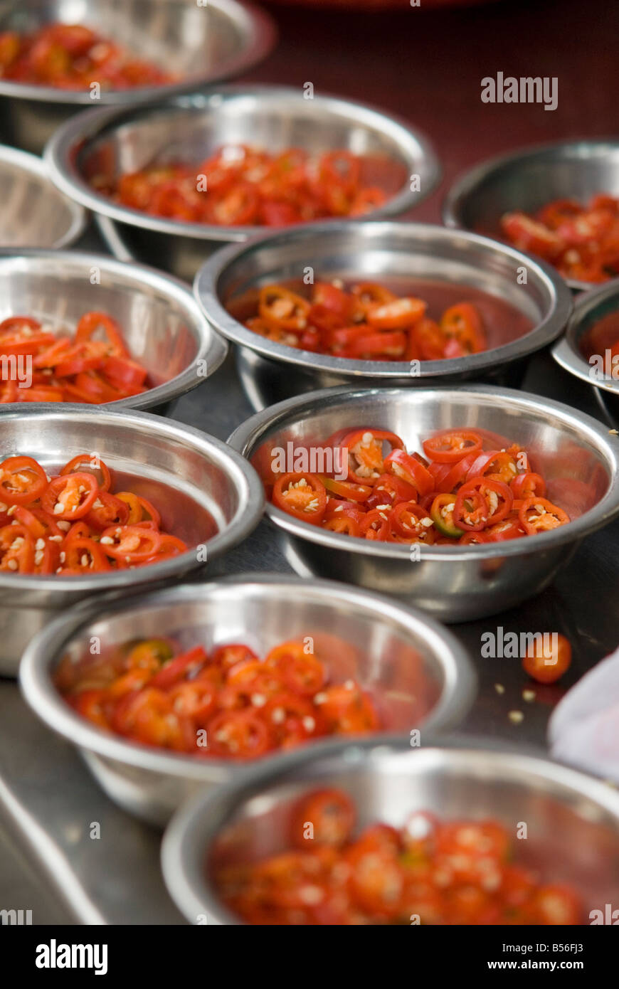 Piccole in acciaio ciotole di trito di peperoncini rossi su un ristorante aperto contatore nella Chinatown di Kuala Lumpur in Malesia Foto Stock