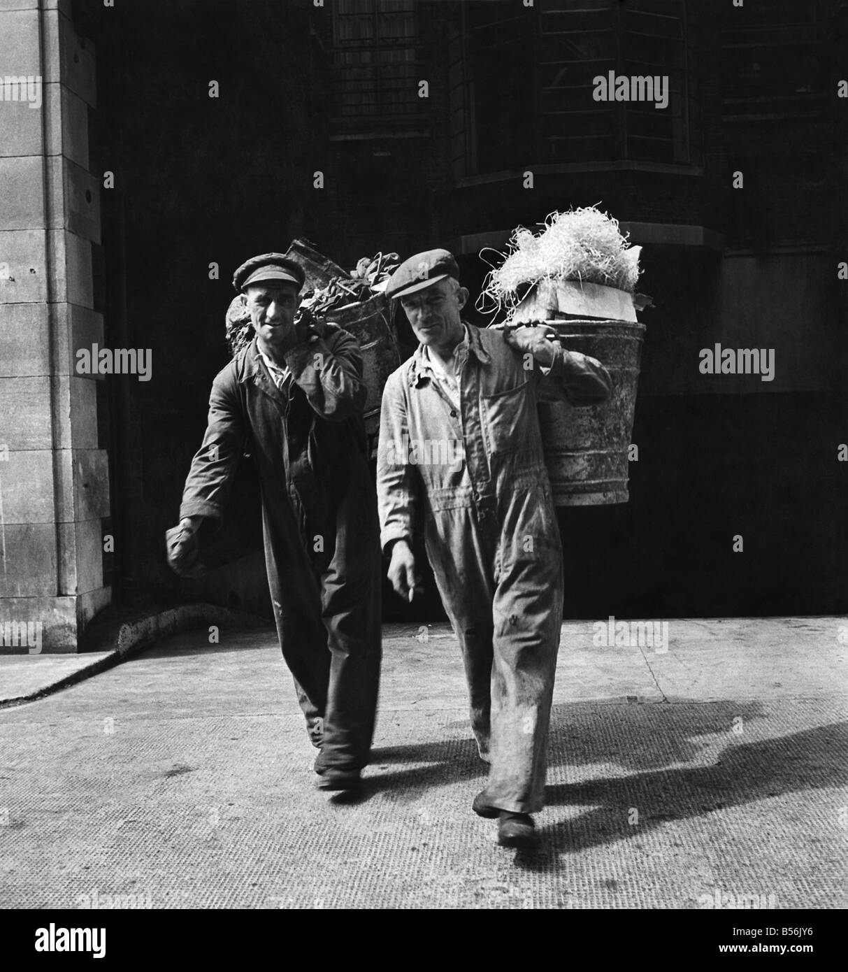Un Cockney guadagna la sua vita: essi hanno scelto il modo più duro per raccogliere un settimanale di pagare il pacchetto - due dustmen lasciare un blocco di appartamenti a Londra dal retro. Agosto 1947 P009118 Foto Stock