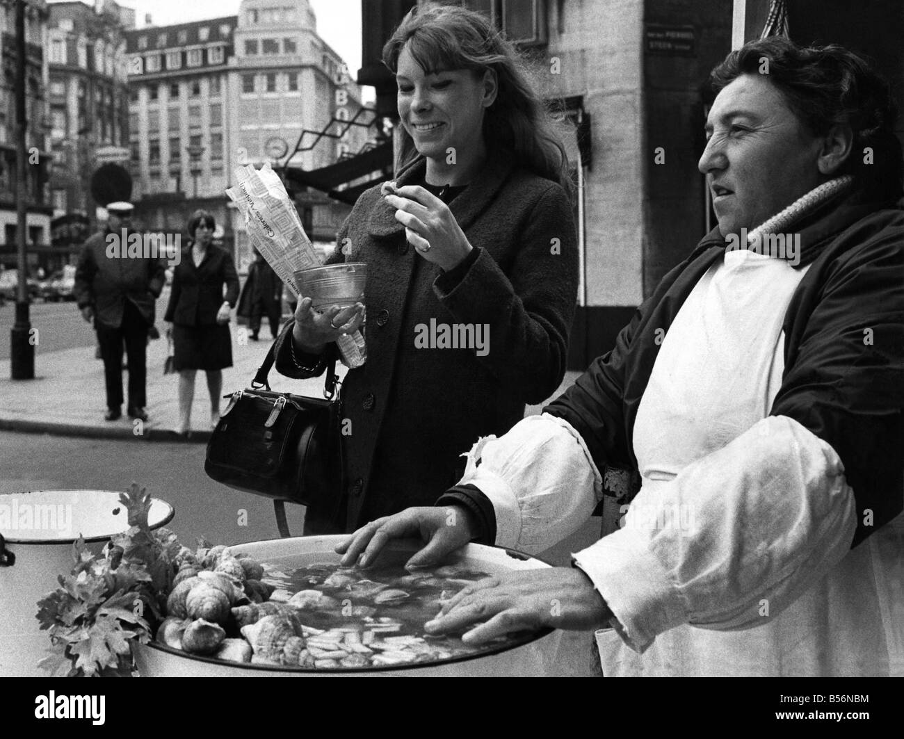 Mangiare lumache in strada Brussles. Madame Jean Piarre Bouffouix. Madame Meysman- Meynaert serve la lumaca da una pentola dal lato strada. Luglio 1966 P009569 Foto Stock