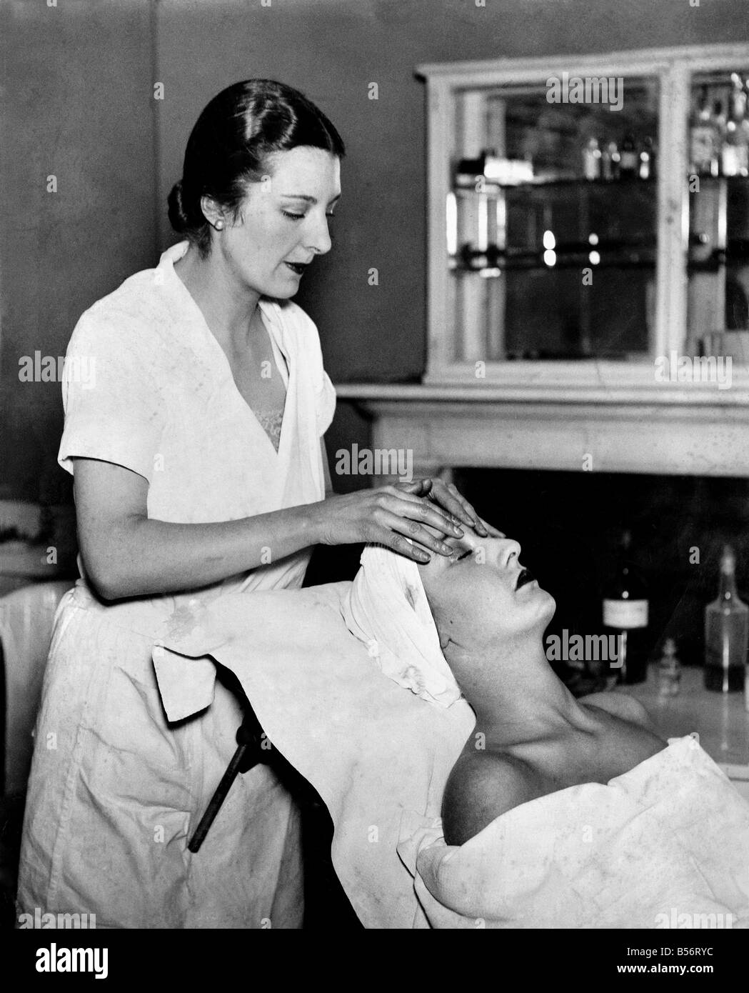 Donna seduta rilassante con i trattamenti di bellezza e massaggi fatto. &#13;&#10;Febbraio 1931 &#13;&#10;P010001 Foto Stock