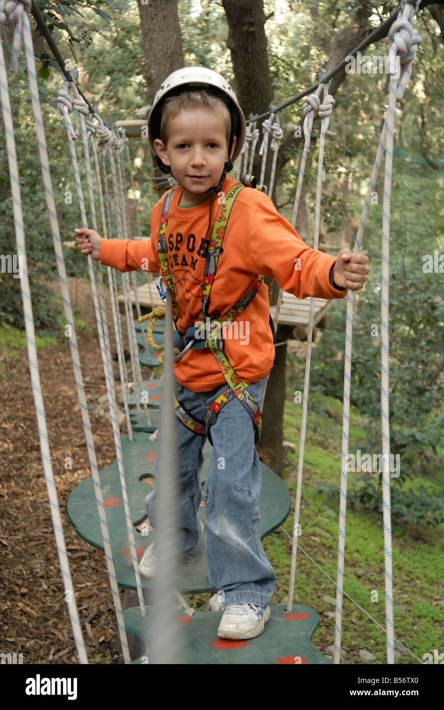 Bambino che va in tree climbing avventura Foto Stock