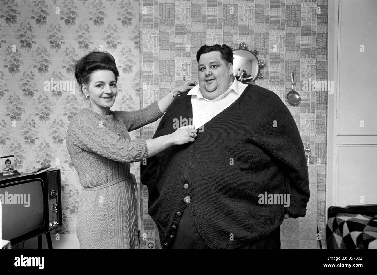 Mondo uomo Fattest: Sig.ra Gwen Matthewman raccordo 38-stone Arthur Armitage con il cardigan che ha avuto il suo 30 ore a lavorare a maglia per lui. Dicembre 1969 Z12233-005 Foto Stock