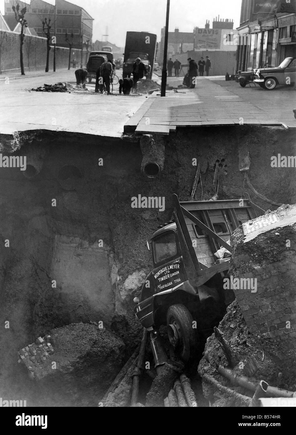 Frane e smottamenti. Venticinque-anno-vecchio camionista Terry Payne ha avuto una notevole fuoriuscita di lunedì ;(1-4-1963) quando il suo veicolo è affondata in un foro che ha aperto la strada principale che collega Woolwich e Plumstead. Aprile 1963 P04442 Foto Stock