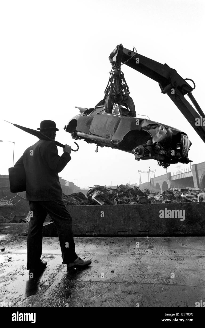 Insolito/Suit/Bowler cappello: Uomo sfridi Jaguar auto: D'altro canto, direttore delle vendite per il sig. Graham Parkes, chi dice che non può più permettersi di eseguire il suo 15 miglia per gallone Jaguar, e era disgustato presso i concessionari' offre, ha deciso di guardare la sua distruzione. Febbraio 1975 75-01164-002-008 Foto Stock
