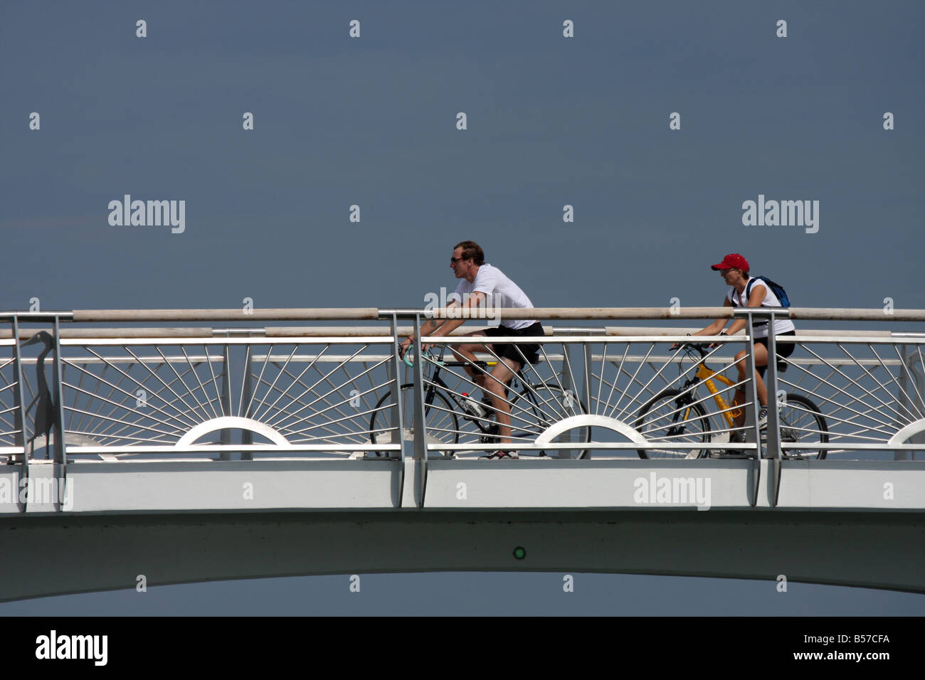 Due biker a cavallo su un ponte al di sopra della baia di fronte al lago di Milwaukee e del Lago Michigan Foto Stock