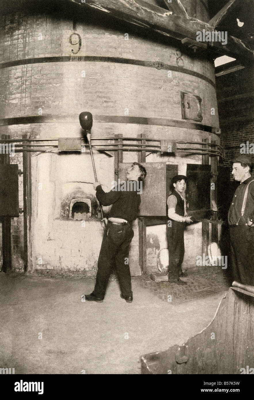Lavoratore la raccolta di vetro fuso su un cannello in una fabbrica di vetro di circa 1900. Mezzitoni di una fotografia Foto Stock
