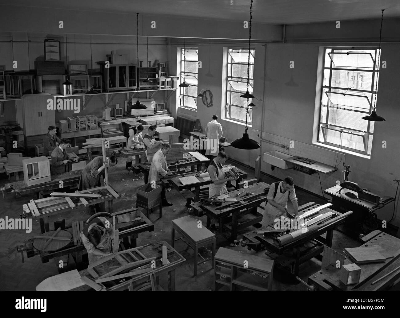 Gli uomini adulti a una formazione in legno e produzione di mobili di classe in una scuola di Leicester, Inghilterra, c. 1955 Foto Stock