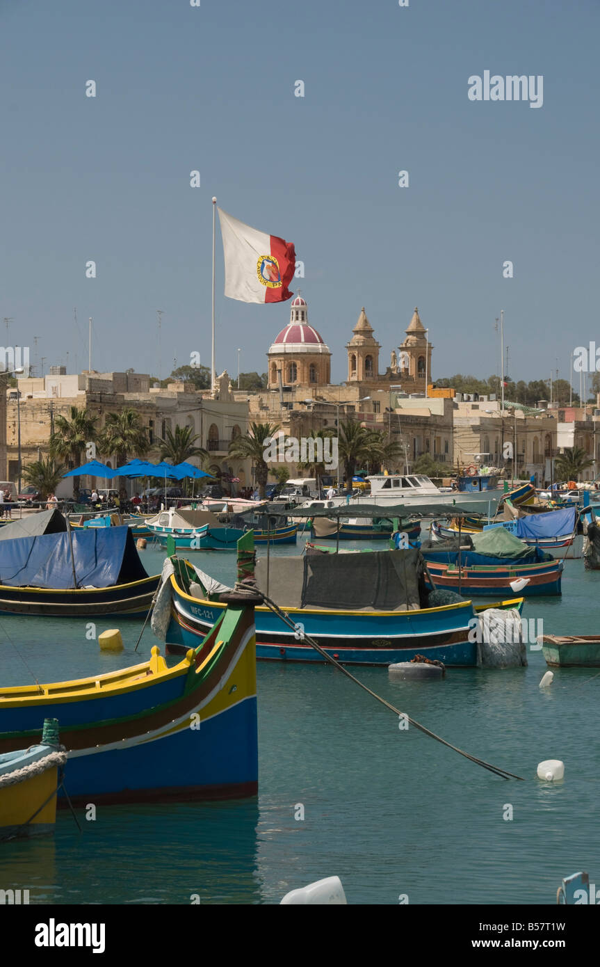 Vivacemente colorate barche da pesca chiamato Luzzus presso il villaggio di pescatori di Marsaxlokk, Malta, Mediterraneo, Europa Foto Stock