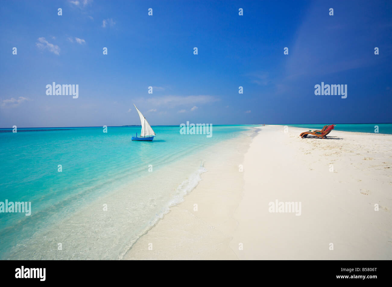 Dhoni e sedie a sdraio sulla spiaggia tropicale, Maldive, Oceano Indiano, Asia Foto Stock