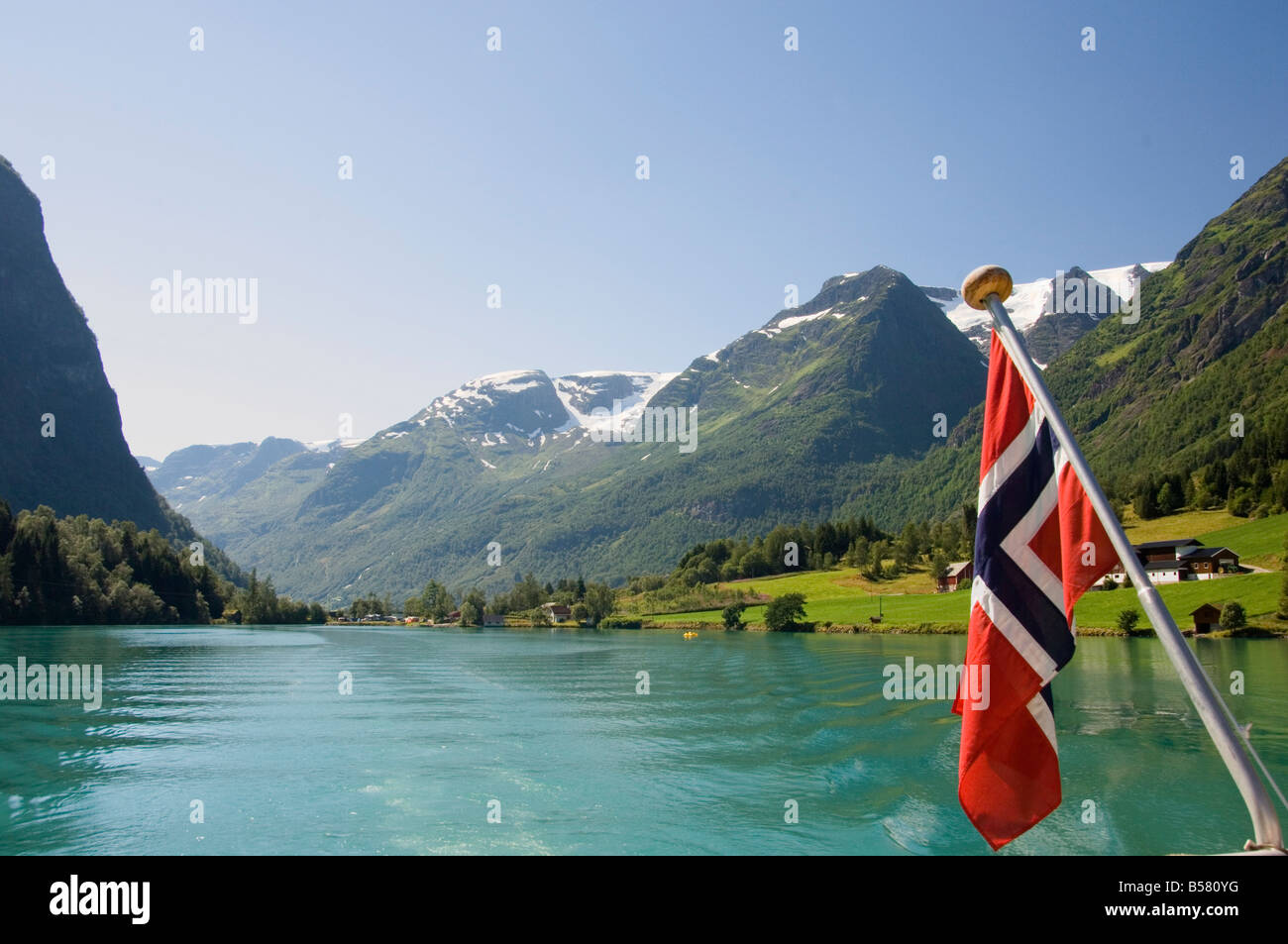 Barca a vela sul lago verde e bandiera norvegese, Olden, Fjordland, Norvegia, Scandinavia, Europa Foto Stock