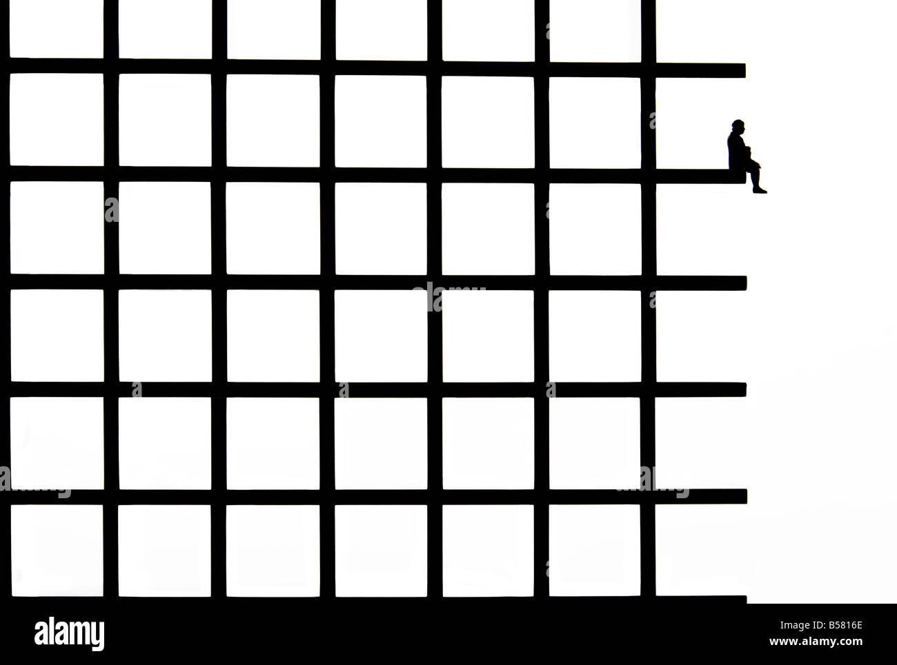 Persona che sale su una struttura a griglia mentre si trova in equilibrio su una sporgenza precaria in un design minimalista Foto Stock