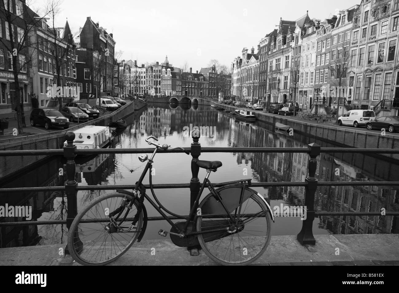 Bianco e nero imge di una vecchia bicicletta mediante il canale Singel, Amsterdam, Paesi Bassi, Europa Foto Stock