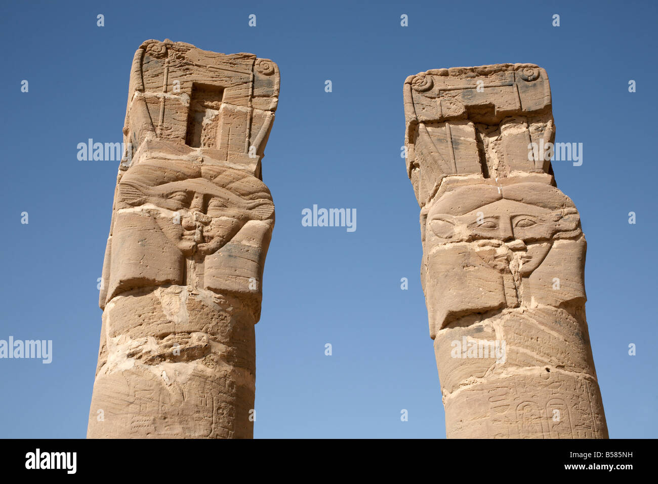 Colonne scolpite stand all'ingresso del tempio di Amon e la santa montagna di Gebel Barkal (Gebel Barkal), Karima, Sudan Foto Stock
