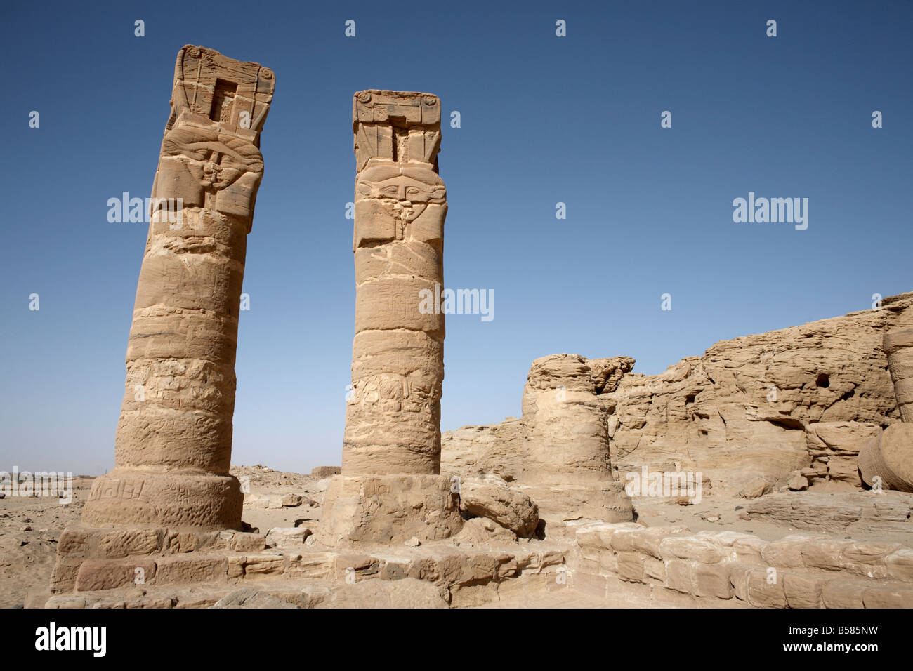 Colonne scolpite stand all'ingresso del tempio di Amon e la santa montagna di Gebel Barkal, Karima, Sudan Foto Stock