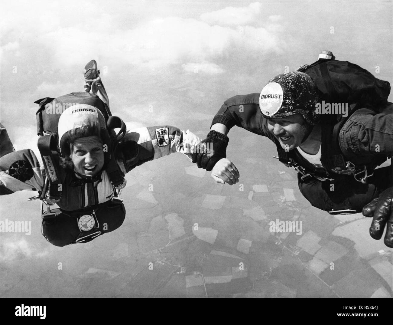 Falling in Love: Romance era davvero in aria per Sally Caino e Jon Williams di domenica (27-5-73). Hanno celebrato il loro impegno che salta fuori da un piano 12.000 ft. al di sopra del suolo. Come sono diminuiti, Jon rinserrata Sally del polso con affetto. E il giovane sorriso felice - proprio come una coppia di innamorati potrebbe essere previsto. Essi non sono stati nervoso. Entrambe appartengono al South Staffordshire Sky Diving Club in base a Halfpenny verde. Quando sbarcarono, Sally , un 24-anno-vecchio Secirity sociale ufficiale di Londra, verificato che il suo anello di fidanzamento era ancora in posizione Foto Stock