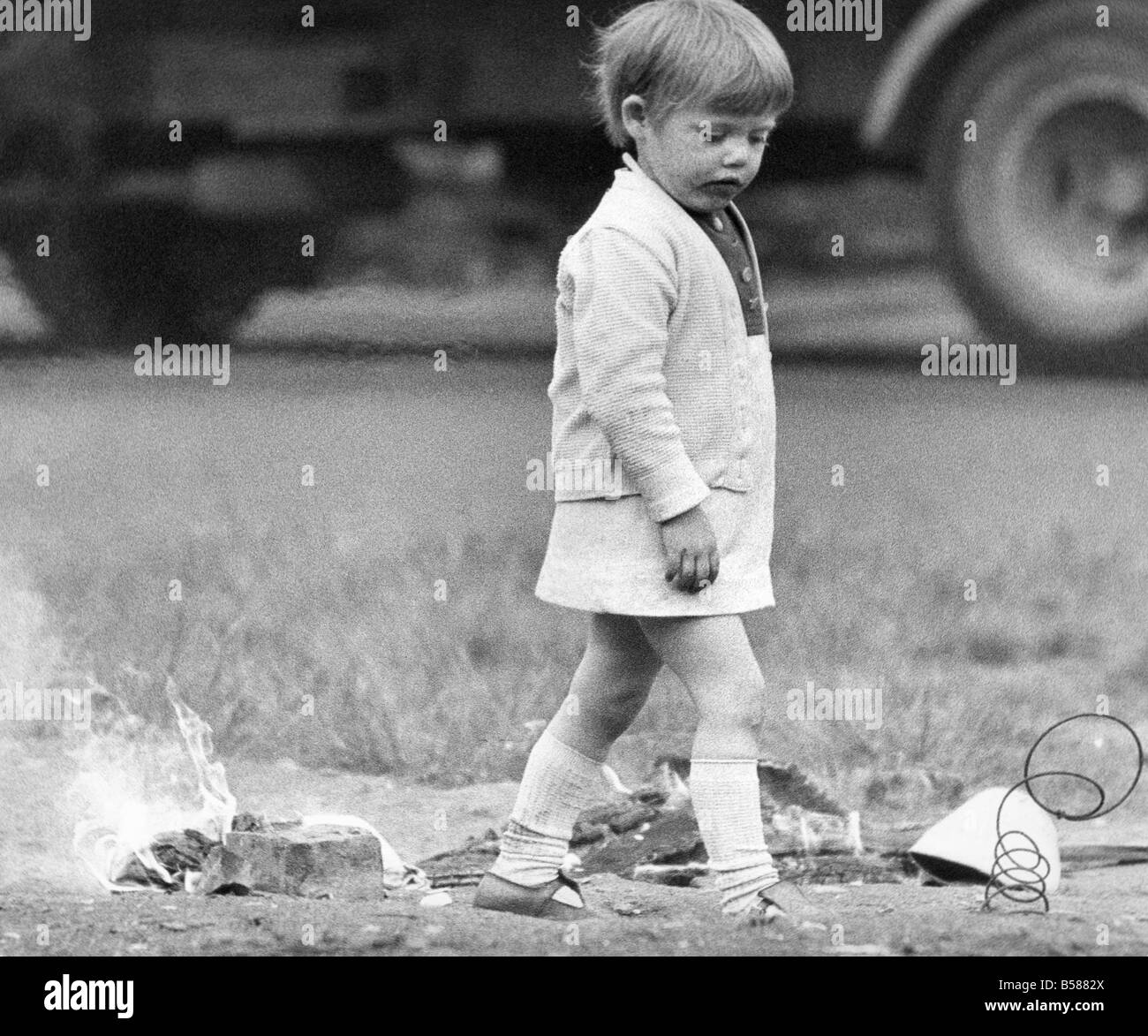 Una giovane ragazza rischia di ferirsi giocando con il fuoco sulla terra desolata 01 11 72circa Foto Stock