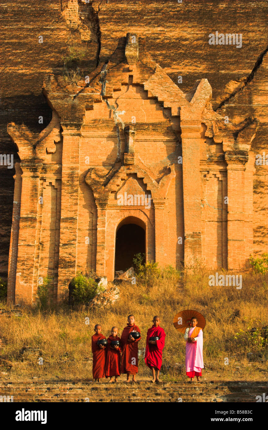 Nun con il debuttante monaci holding alms bocce a Mingun Paya Mingun Mandalay MYANMAR Birmania Asia Foto Stock