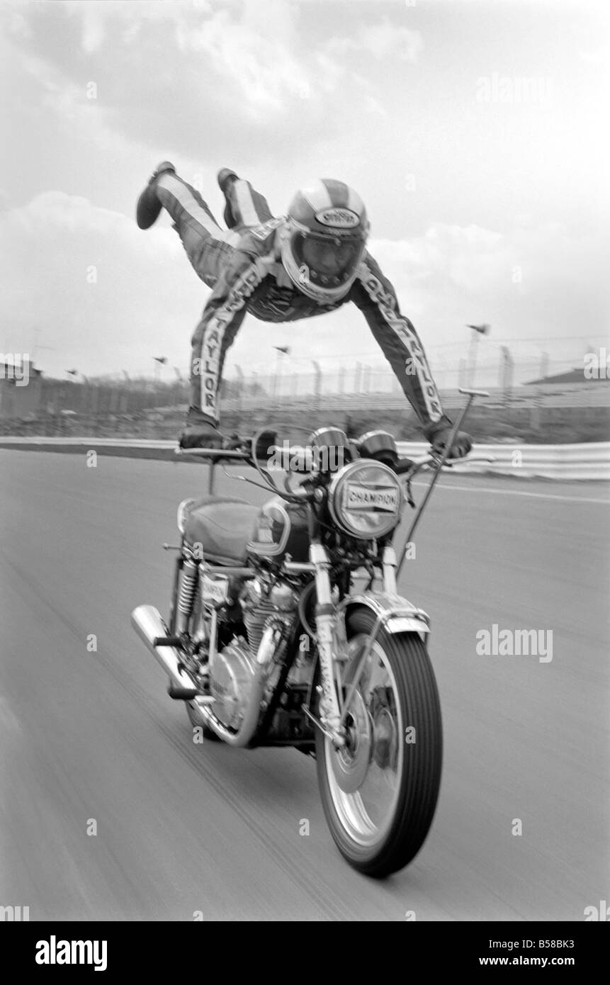 Moto stunt: Dave Taylor vive a Barnhurst vicino a Bexley Kent. È sposato con tre figli. Dave sta eseguendo un serbatoio di stand a 90 mph lungo il rettilineo di finitura a Brands Hatch racing percorso benessere. Questa è stata una corsa lenta. Egli non ha fatto questo a oltre 100 M.P.H. Aprile 1977 77-02121-001 Foto Stock