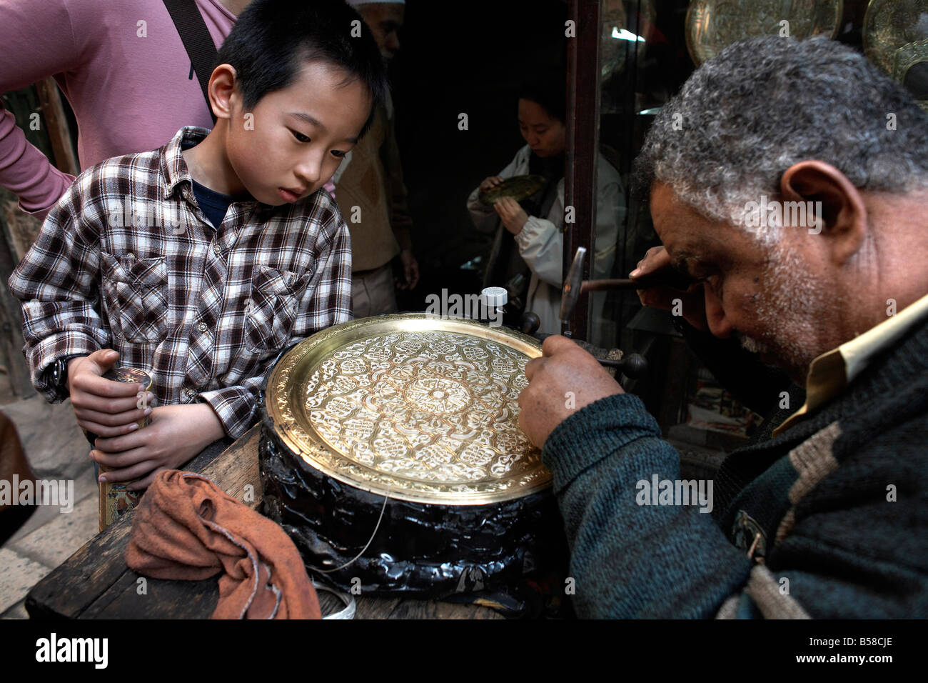 I turisti guarda un incisore nel grande bazar di Khan al-Khalili al Cairo, Egitto, Africa Settentrionale, Africa Foto Stock