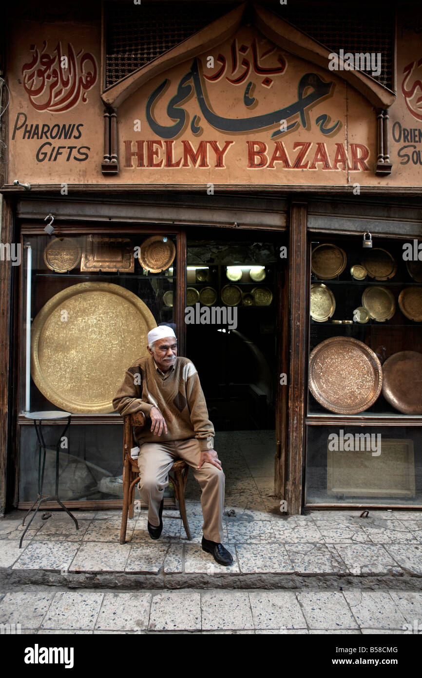 Proprietario del negozio si rilassa nel grande bazar di Khan al-Khalili al Cairo, Egitto, Africa Foto Stock