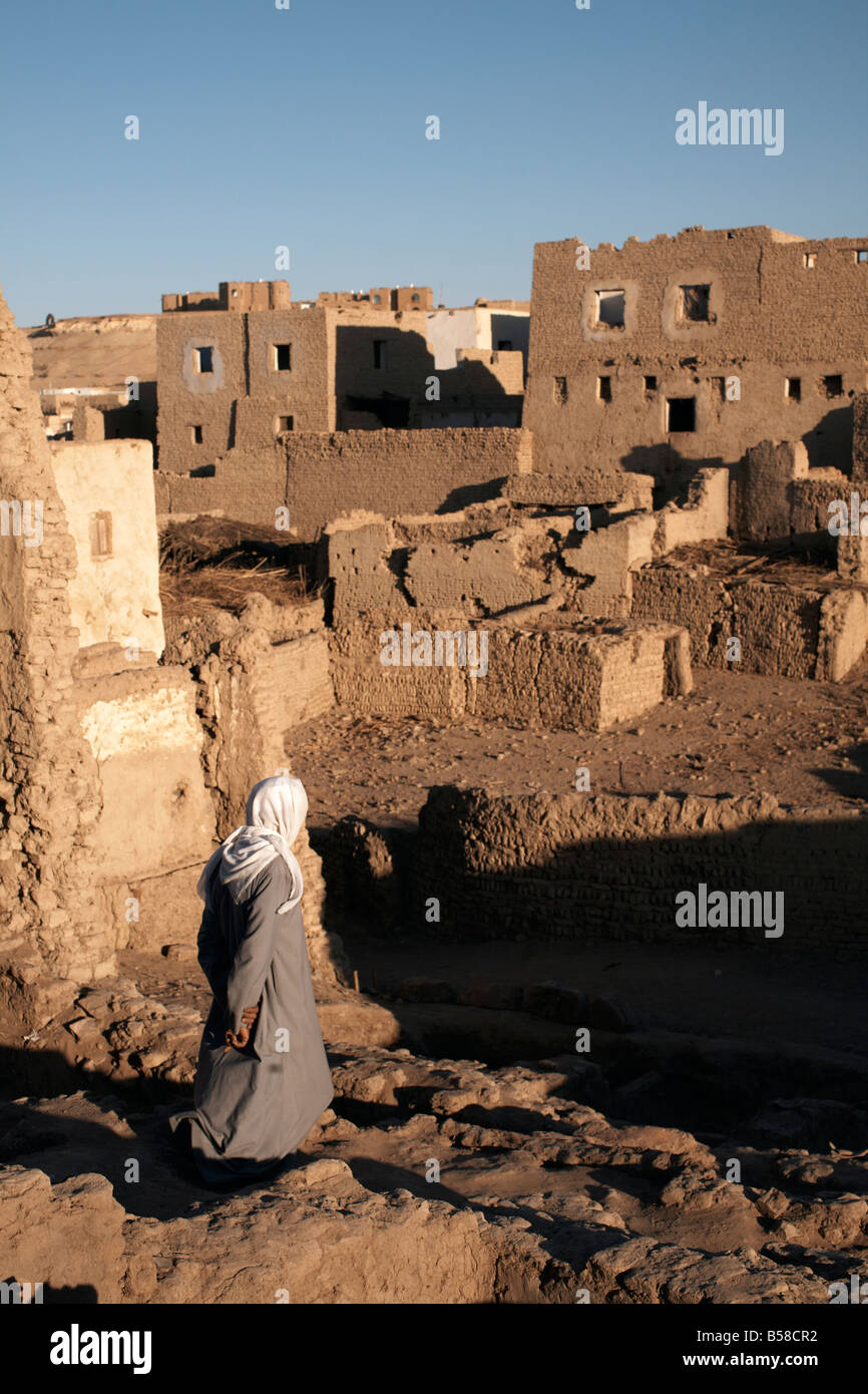 Un uomo si erge tra la rovina dei mattoni di fango città di Al-Qasr, Dakhla Oasis, Egitto, Africa Settentrionale, Africa Foto Stock