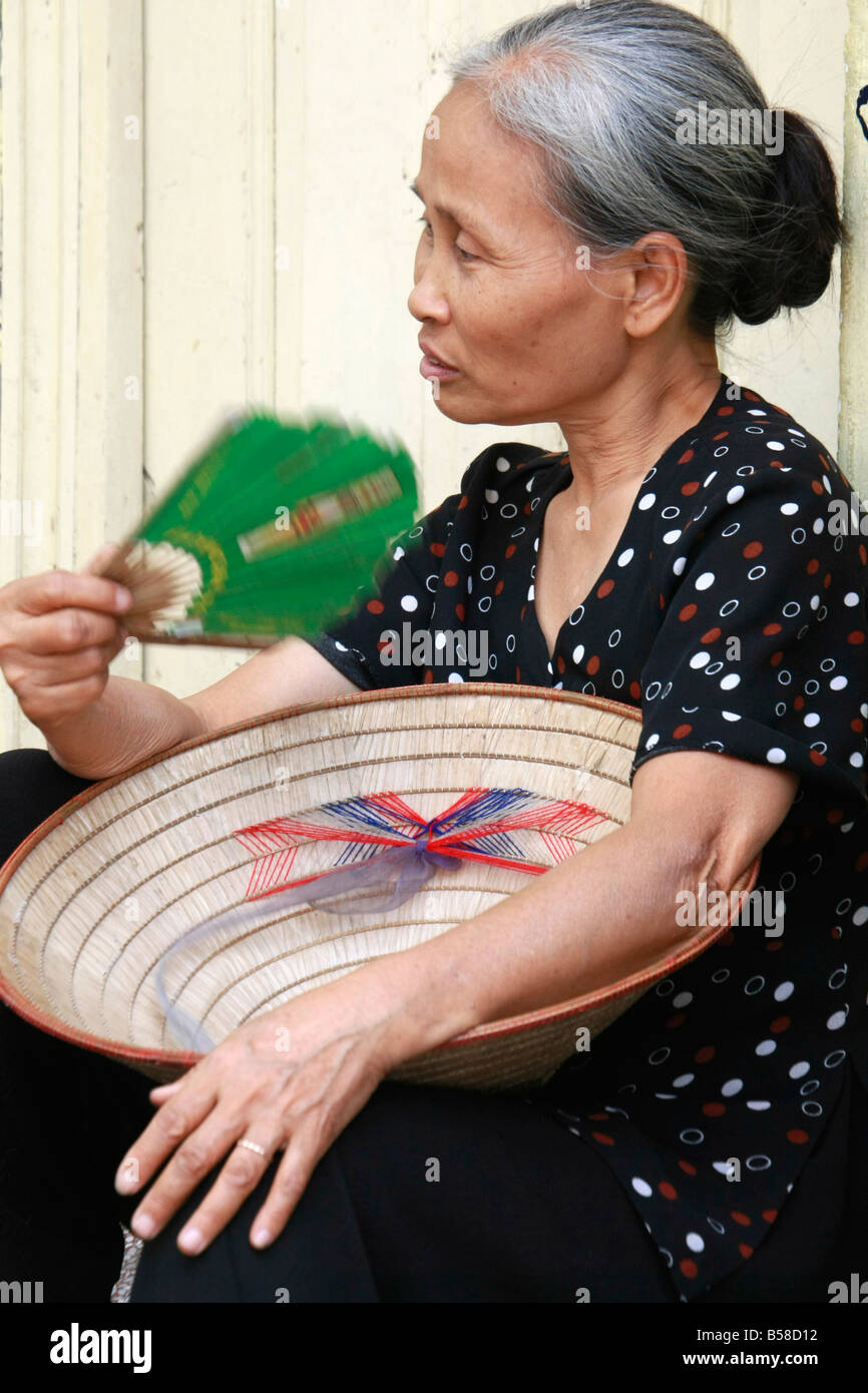 Donna vietnamita in appoggio in strada, Hanoi, Vietnam Foto Stock