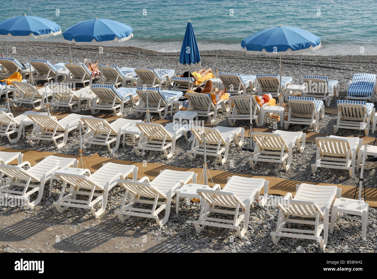 Sedie a sdraio sulla spiaggia a Nizza in Francia Foto Stock