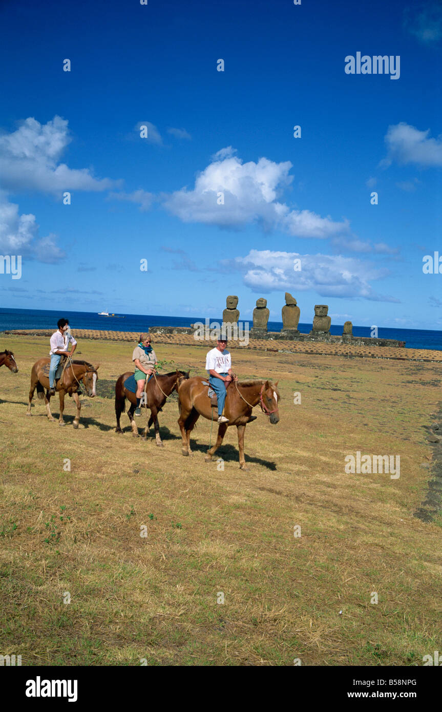 I turisti a cavallo touring siti di moai o statue a Ahu Vai Uri sull isola di pasqua Cile Pacific G Renner Foto Stock