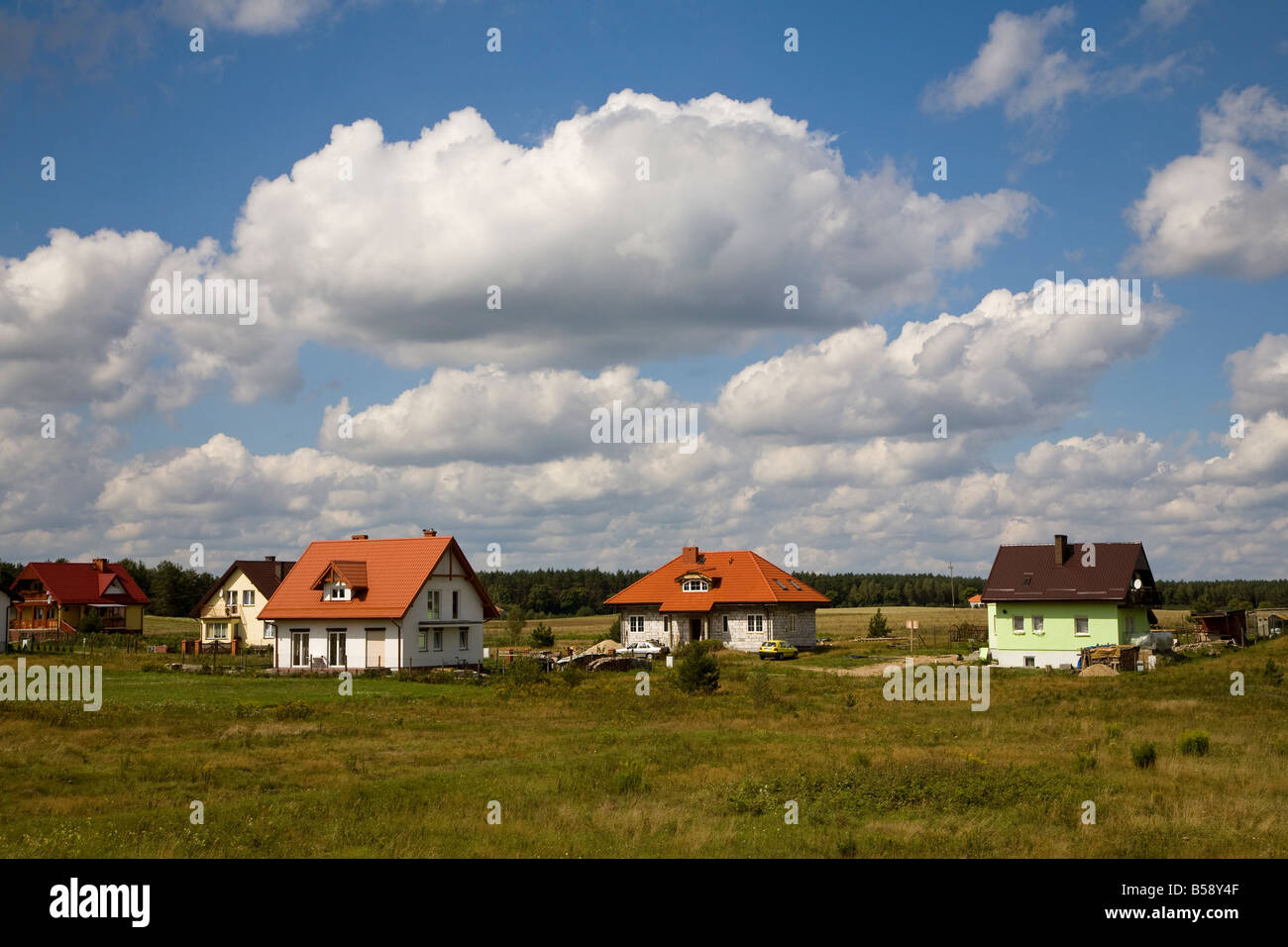 Case in campo verde impostazione sul bordo del villaggio Miastko Polonia Foto Stock