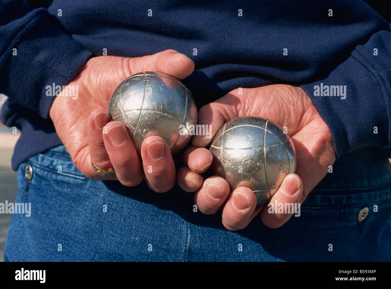 Close up di mani tenendo in color argento di Sfere utilizzate nel gioco delle bocce in Roussillon Francia G Thouvenin Foto Stock