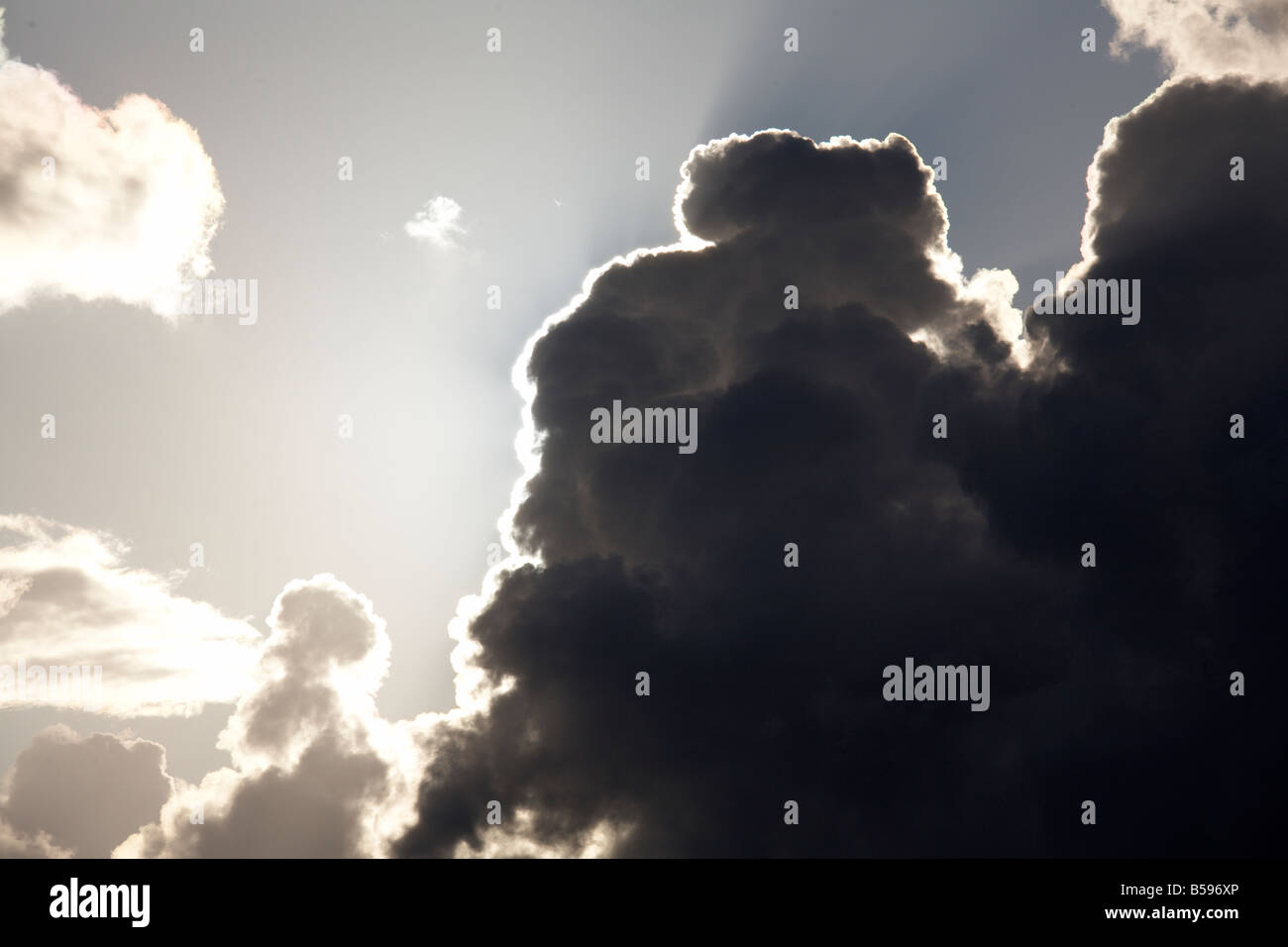 Grigio scuro drammatica cumulus nuvole con rivestimenti in argento e raggi o alberi di luce del sole in Brisbane Queensland QLD Australia Foto Stock