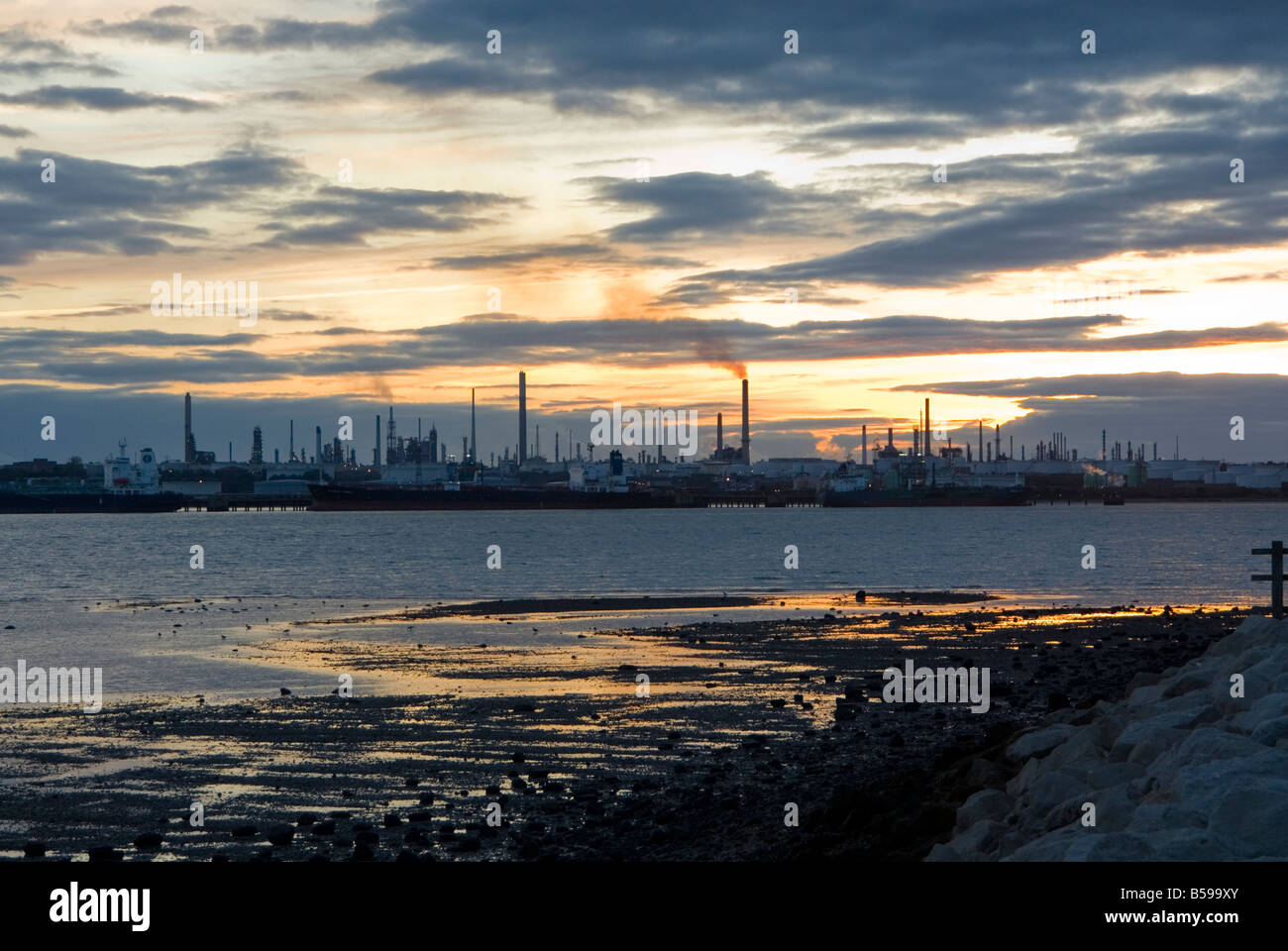 Fawley raffineria di petrolio su acqua di Southampton, Hampshire, Inghilterra al crepuscolo Foto Stock