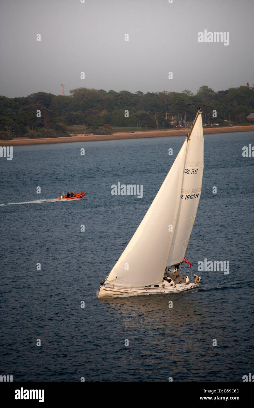 Barca a vela o nave sbandata di yacht over sul mare in acqua di Southampton England Regno Unito Foto Stock