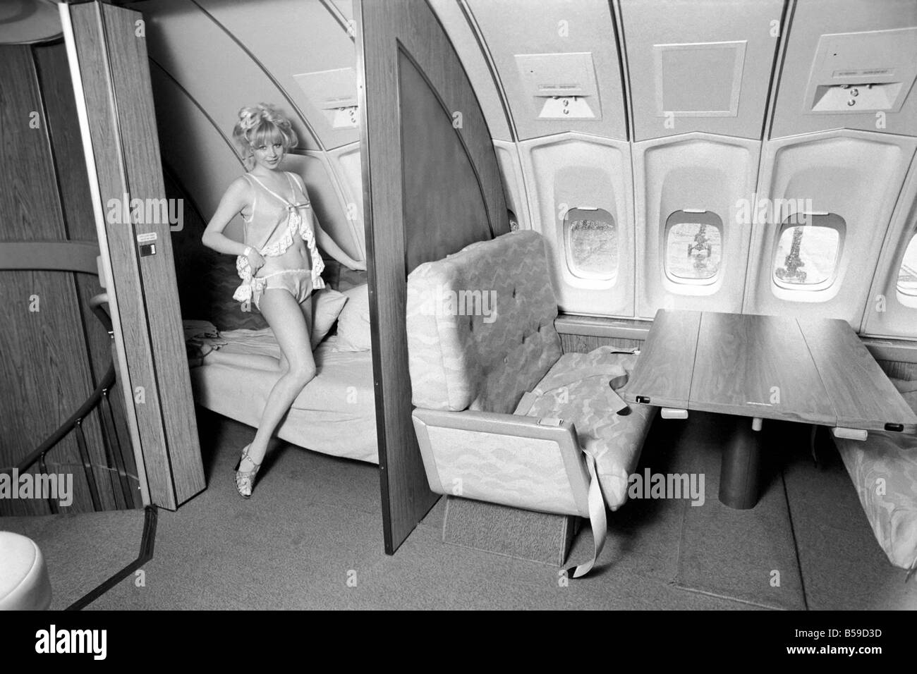 I jumbo jet: Notte: Prima Classe: camera da letto nel cielo: 23 anni di vecchio modello Jenny Clare, illustra il modo in cui è possibile rilassarsi e dormire se sorge la necessità, al di sopra del primo vano di classe di Singapore International compagnia aerea Jumbo 747 piano. La first class lounge conduce fino dalla prima classe dal vano 13 scale e sperano di trasformarla in un dormitorio. Aprile 1975 75-1950-005 Foto Stock