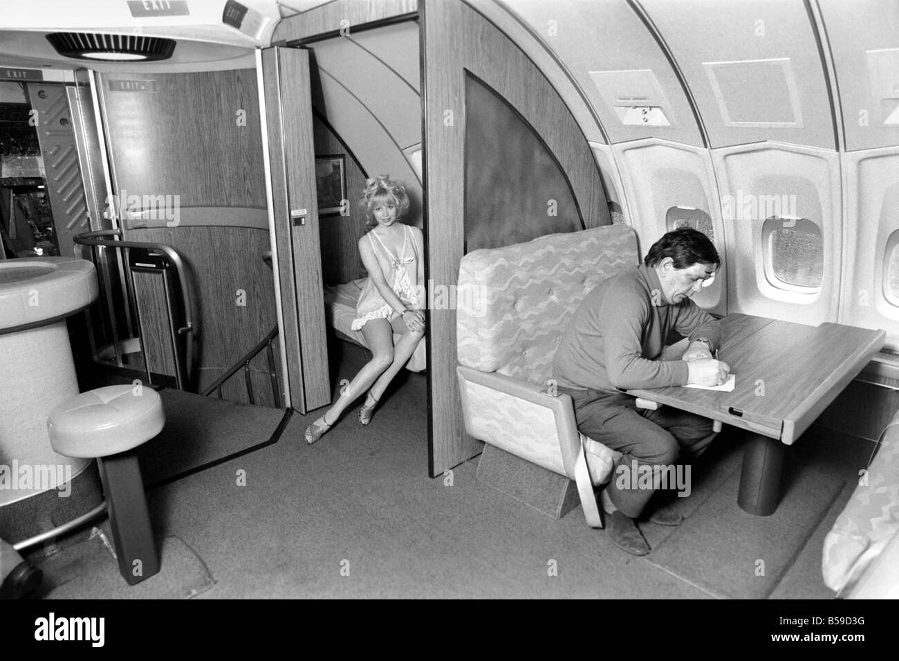 I jumbo jet: Notte: Prima Classe: camera da letto nel cielo: 23 anni di vecchio modello Jenny Clare, illustra il modo in cui è possibile rilassarsi e dormire se sorge la necessità, al di sopra del primo vano di classe di Singapore International compagnia aerea Jumbo 747 piano. La first class lounge conduce fino dalla prima classe dal vano 13 scale e sperano di trasformarla in un dormitorio. Aprile 1975 75-1950 Foto Stock